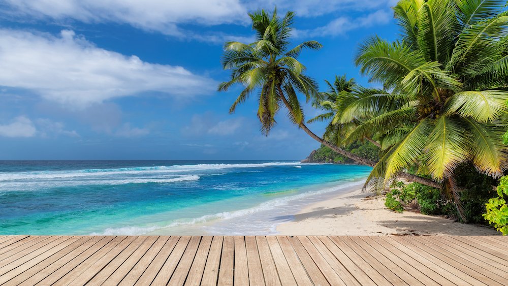 Beach wooden table and coconut palms with party on tropical beach background.